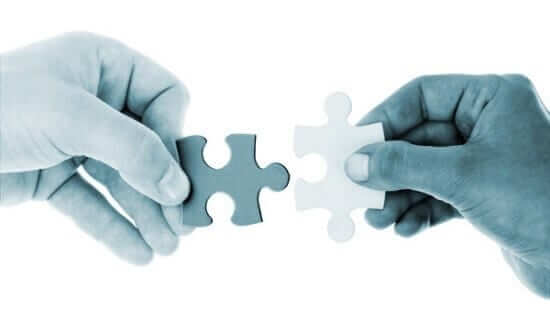 Two hands holding pieces of puzzle image